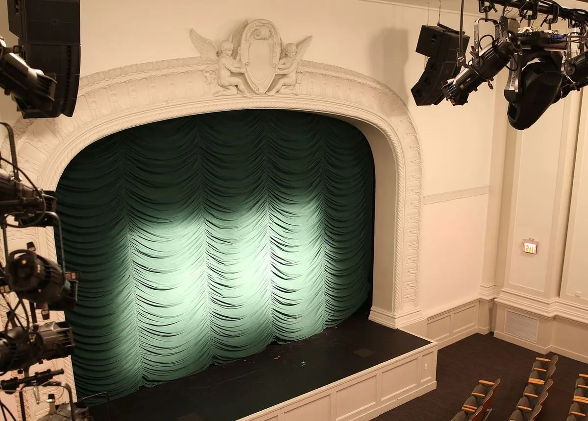 The Loreto Theater at the Sheen Center, seen from the mezzanine: a plaster proscenium with cherubs above a green curtain